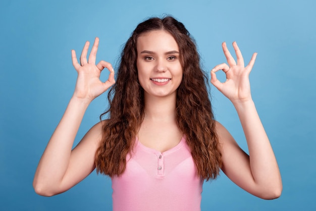 Foto van een charmante dame voor de jeugd toont vingers okey symbool geweldige promotie-advertenties geïsoleerd over blauwe kleur achtergrond.
