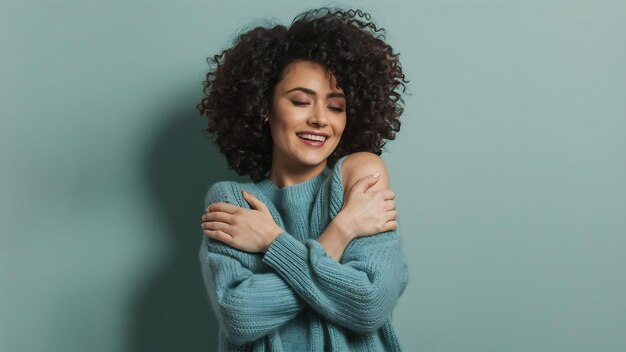 Foto van een charmante vrouw die zelfliefde en zorg uitdrukt en geniet van het dragen van een nieuwe zachte groene trui.