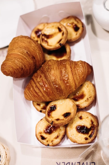 Foto van een doos met verse croissants en koekjes