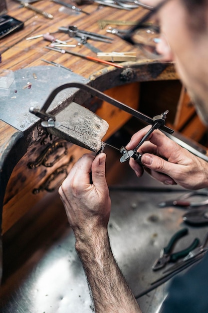 Foto foto van een geconcentreerde man die met gereedschappen werkt in een ambachtelijke werkplaats