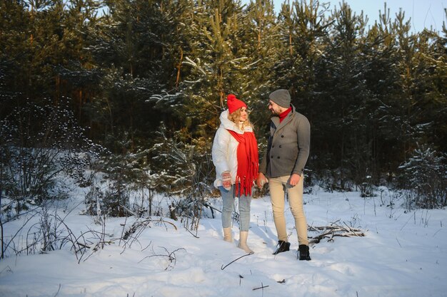 Foto van een jong, aantrekkelijk stel, gelukkige positieve glimlach, kijk naar elkaar, geniet van de tijd samen, bos winter liefdesverhaal