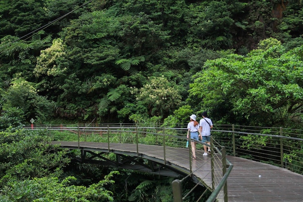 Foto van een jong stel met een wit t-shirt staat op een houten brug. Jiufen-Jinguashi, Taiwan