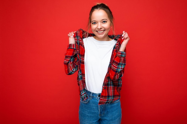 Foto van een jonge, aantrekkelijke, vrolijke glimlachende hipster-blonde vrouw in een stijlvol rood shirt en