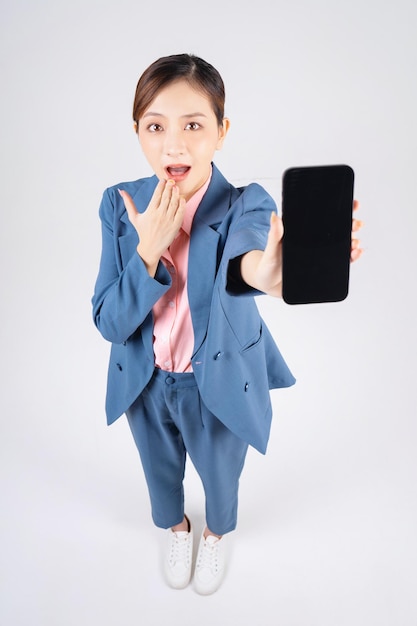 Foto van een jonge Aziatische zakenvrouw die een smartphone gebruikt