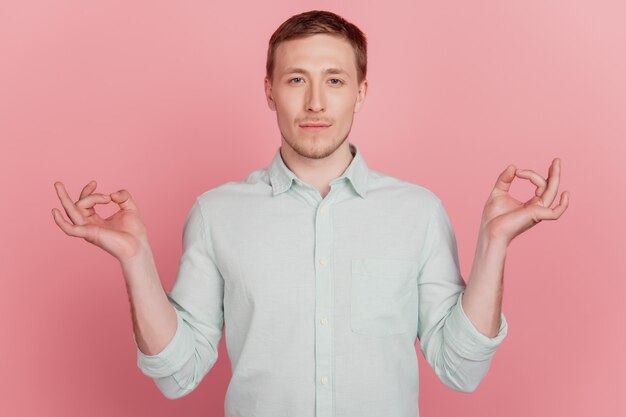 Foto van een jonge knappe man die yoga beoefent, kalm om zen, mediteer vredige geïsoleerde roze kleur achtergrond