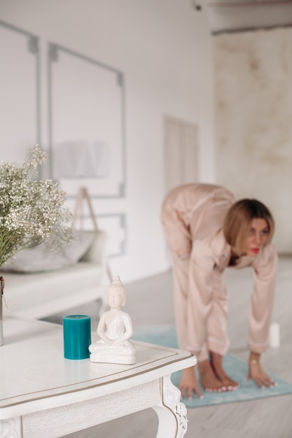 Foto van een jonge, mooie magere vrouw die 's ochtends yoga doet in verschillende poses