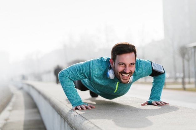 Foto van een jonge sportman die buiten push-ups doet, fitness en oefeningen doet