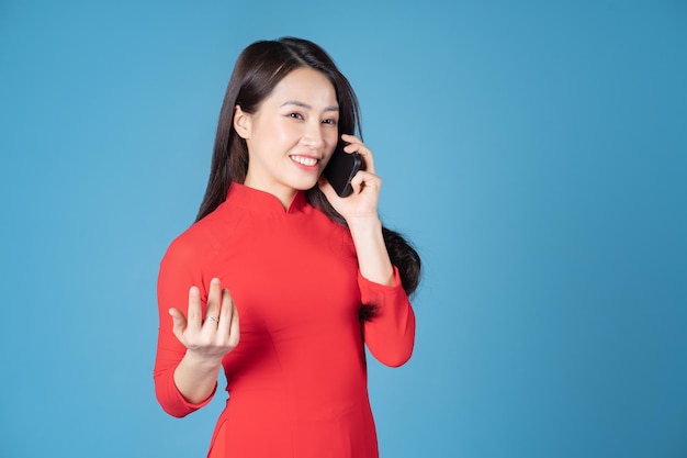 Foto van een jonge Vietnamese vrouw die rode ao dai . draagt