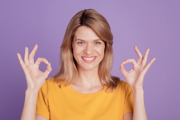 Foto van een jonge, vrolijke vrouw, blije positieve glimlach, laat zien oké perfect cool gedaan cool geïsoleerd over violette kleurachtergrond