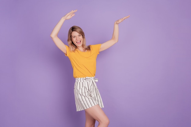 Foto van een jonge, vrolijke vrouw, een gelukkige positieve glimlach, veel plezier dans hiphop schar geïsoleerd over een violette kleurachtergrond