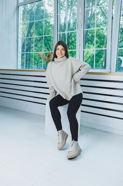 Foto van een jonge vrouw in witte laarzen en vrijetijdskleding Nieuwe collectie winterschoenen voor dames van echt leer