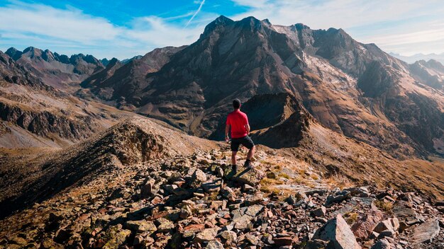 Foto van een jongen die de onmetelijkheid van de bergen in de Panticosa-vallei bewondert, een dag wandelen.