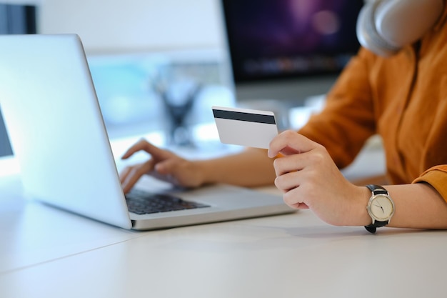 Foto van een kantoorvrouw met een creditcard en een laptop.