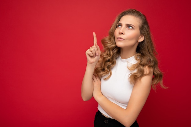 Foto van een leuke, innemende, boze, ontevreden volwassen vrouw met een casual outfit geïsoleerd op de achtergrondmuur met kopieerruimte wijzend op vrije ruimte met handen