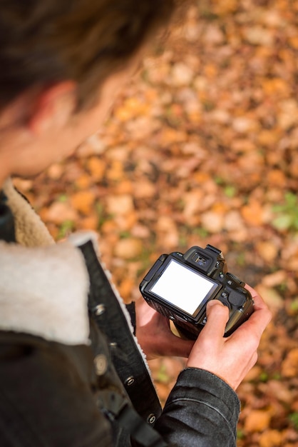 Foto van een man die de camera in zijn handen houdt en door de foto's kijkt die hij zojuist heeft gemaakt