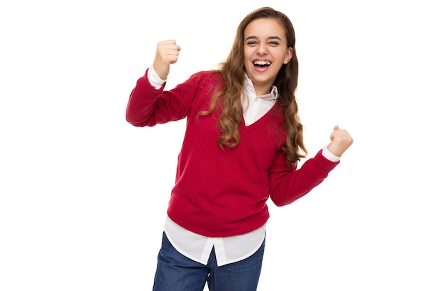 Foto van een mooi, charmant, glimlachend, gelukkig brunette tienermeisje met lang haar in stijlvol rood