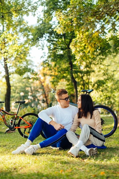 foto van een mooi romantisch koppel, vriend en vriendin zittend op een groen grasveld in het park