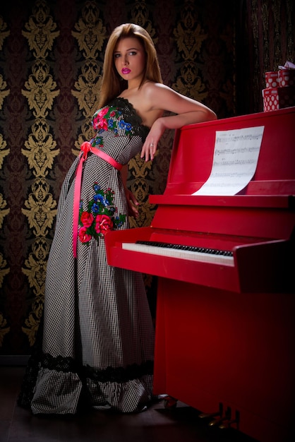 Foto van een mooi tienermeisje dat filmt in de studio in de buurt van de piano, een verscheidenheid aan afbeeldingen