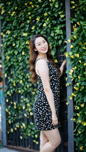Foto van een mooie Aziatische vrouw met een print top die poseert bij een tuin generatieve AI