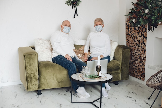 Foto van een oud paar verliefd op medische maskers brengt samen kersttijd door