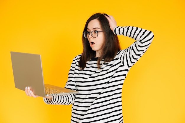 Foto van een schattige beïnvloedbare dame in een gestreept t-shirt met bril die het nieuws leest of schrijft