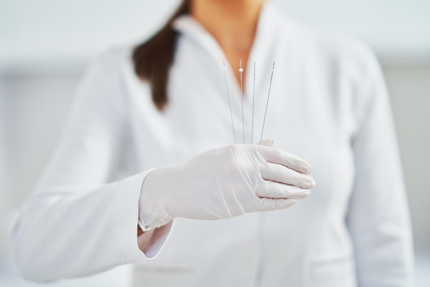 Foto van een vrouw die cosmetische draden vasthoudt terwijl ze handschoenen draagt