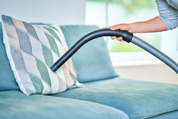 Foto van een vrouw die het huis schoonmaakt met vacuüm