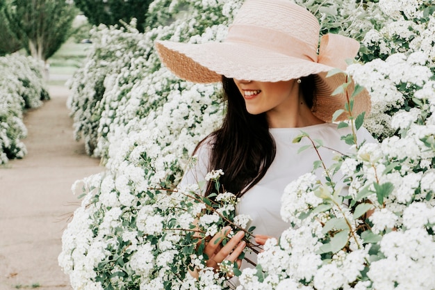 Foto van een vrouw in een hoed en bloemen.