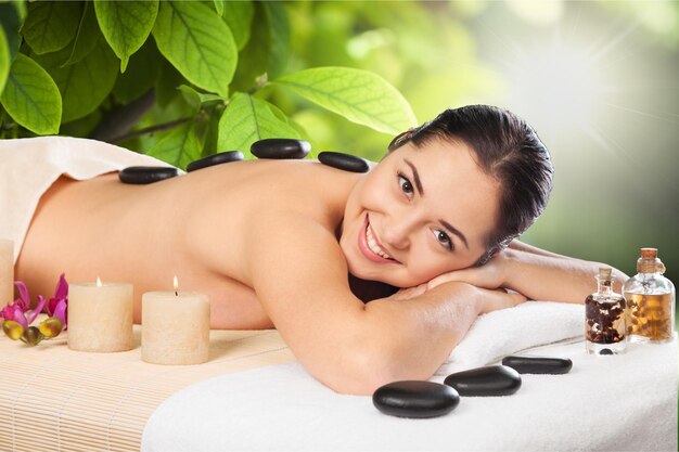 Foto van een vrouw in een spa salon met hete stenen.