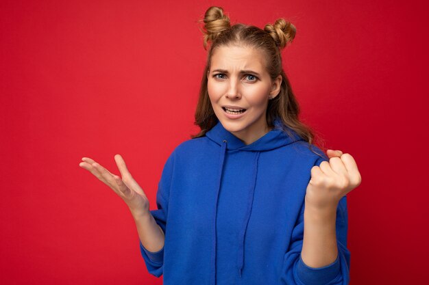 Foto van emotionele agressieve jonge mooie blonde vrouw met oprechte emoties blauw dragen