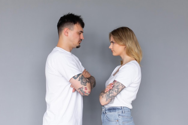 Foto van geïrriteerd agressief stel man en vrouw in basic t-shirts die tegen elkaar schreeuwen