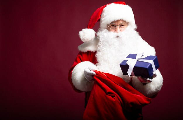 Foto van gelukkig lachend Kerstman met geschenkdozen is poseren