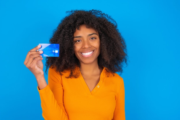 Foto van gelukkige vrolijke lachende positieve vrouw beveelt creditcard aan