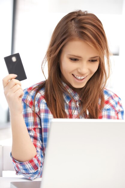 foto van gelukkige vrouw met laptopcomputer en creditcard