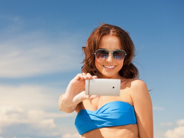 foto van gelukkige vrouw met telefoon op het strand.