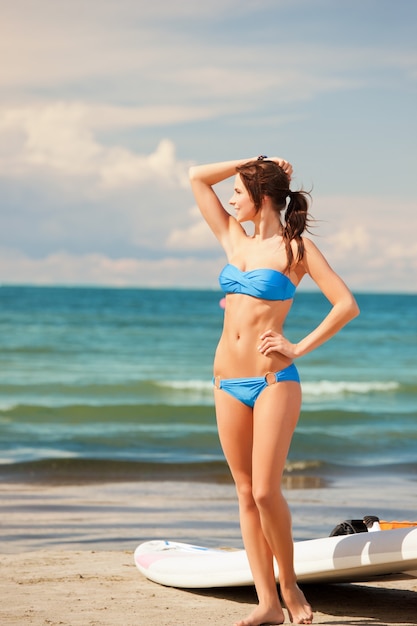 foto van gelukkige vrouw met windsurfen op het strand.