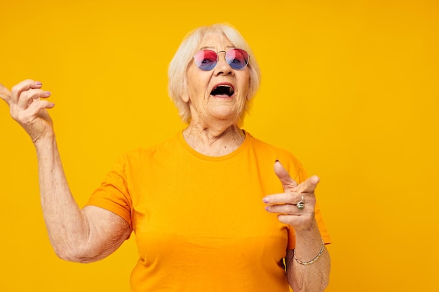 Foto van gepensioneerde oude dame gelukkige levensstijl in gele t-shirts bijgesneden weergave