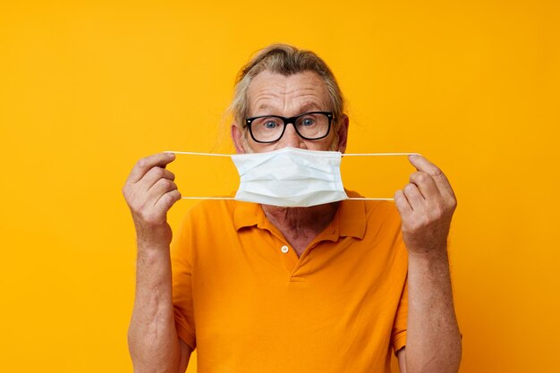 Foto van gepensioneerde oude man medisch masker op de gezichtsbescherming close-up geïsoleerde achtergrond