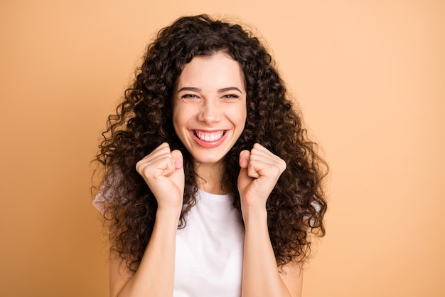 Foto van geweldige dame luisteren geweldige reclame verkoop winkelen triomfantelijk verhogen vuisten dragen witte vrijetijdskleding geïsoleerde beige pastelkleur achtergrond