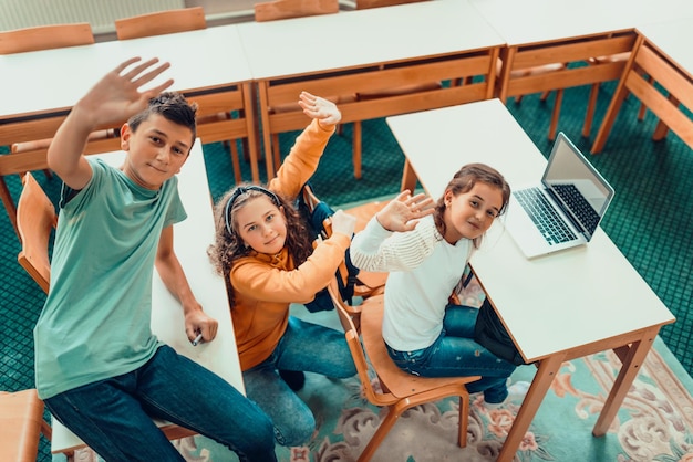 Foto van het bovenaanzicht van een groep schoolkinderen die op laptop leren met hun leraar tijdens een les in de klas Selectieve focus Foto van hoge kwaliteit