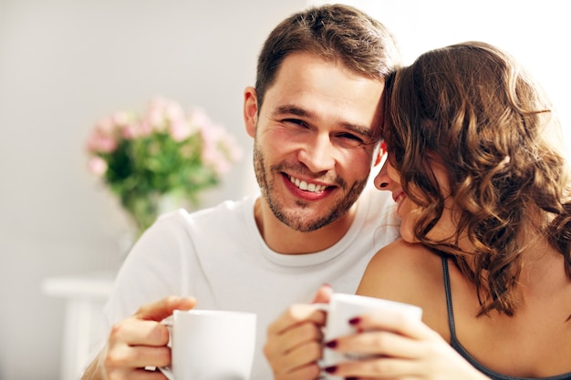 Foto van jong stel dat koffie drinkt in bed