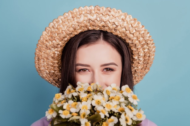 Foto van jonge aantrekkelijke dame dekking gezicht wilde bloemen bos cadeau dromerig geïsoleerd over groenblauw gekleurde achtergrond