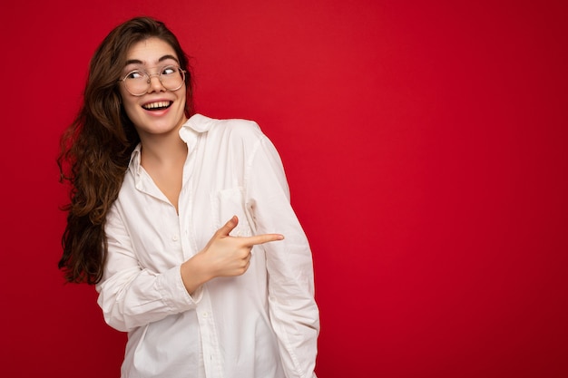 Foto van jonge mooie gelukkig lachende brunette vrouw met wit overhemd en optische bril sexy