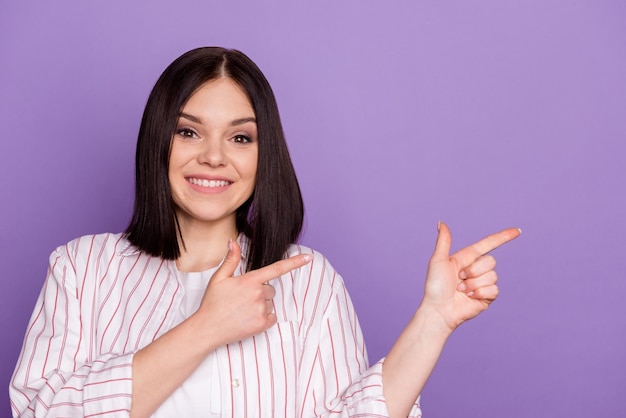 Foto van jonge vrolijke vrouw geeft aan dat de beslissing over de lege ruimte van de vingers advertenties suggereert die zijn geïsoleerd over een violette kleurachtergrond