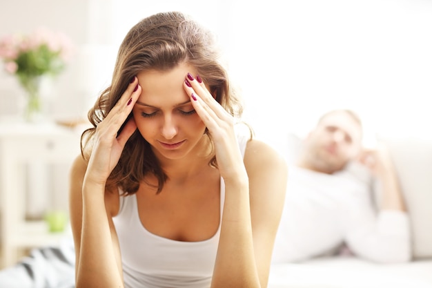 Foto van jonge vrouw en haar man die problemen hebben in de slaapkamer