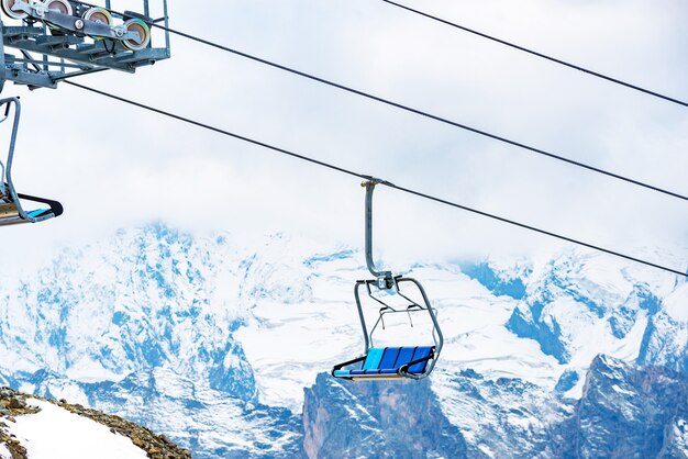 Foto van kabelbanen tussen besneeuwde bergheuvels.