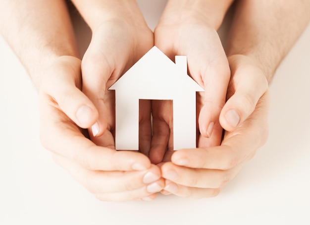 Foto van man en vrouw handen met papieren huis