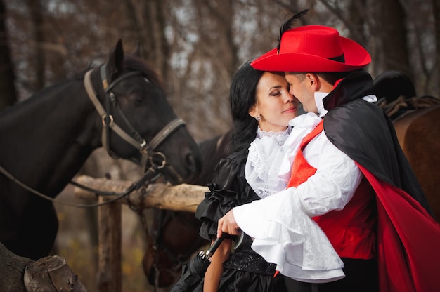 Foto van man en vrouw in prachtige theaterkostuums in het bos