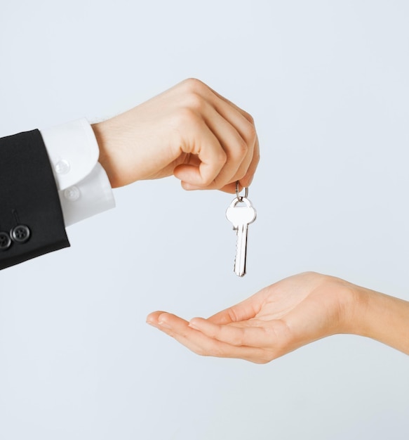 foto van man hand die huissleutels doorgeeft aan vrouw