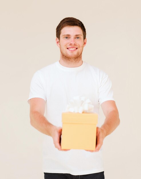 foto van man in wit t-shirt met geschenkdoos
